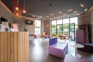 a room with chairs and tables and windows at Hotel Stadio & Spa in San Bonifacio