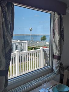 a large window with a view of the ocean at Panoramic Views Relaxing Caravan Littlesea Haven Weymouth in Weymouth