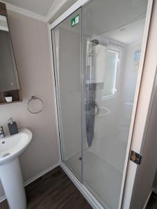 a bathroom with a shower and a sink at Panoramic Views Relaxing Caravan Littlesea Haven Weymouth in Weymouth
