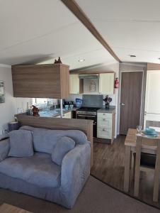 a living room with a couch and a kitchen at Panoramic Views Relaxing Caravan Littlesea Haven Weymouth in Weymouth