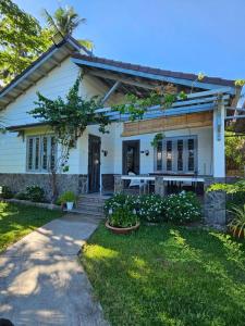 una casa blanca con una mesa en el patio en Catsen Bungalows & Pool Phan Thiet en Phan Thiet