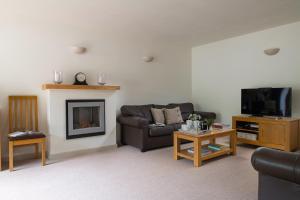 a living room with a couch and a fireplace at Dorset Holiday Barns in Sherborne