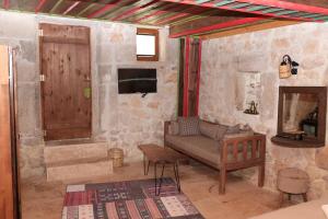 a living room with a couch and a tv and a door at Casa Di Cappadocia in Uchisar