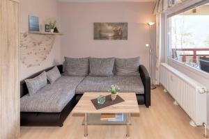 a living room with a couch and a table at Terrassenhaus, FeWo 19 in Duhnen