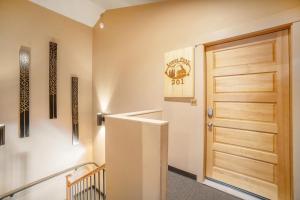 - un couloir avec une porte en bois et des escaliers dans l'établissement Solitude Longs Peak Suite 201 - Estes Park studio, à Estes Park