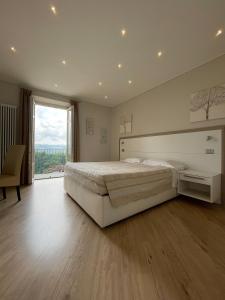 a bedroom with a large bed and a large window at La Rocca in Carrù