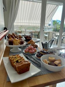 un tavolo con diversi tipi di pane e prodotti da forno di Hotel Riva e Mare a Rimini