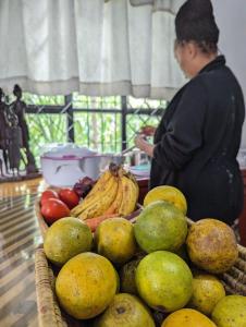 a person standing in front of a table of fruit at Elizabeth Home in Arusha