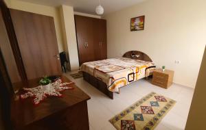 1 dormitorio con cama, mesa y sidra de mesa en Lucky's apartment, a place to be, en Pogradec