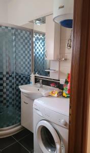 een badkamer met een wasmachine en een wastafel bij Lucky's apartment, a place to be in Pogradec