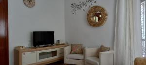 a living room with a tv and two chairs at Apartamento Sevilla 3 in La Guardia