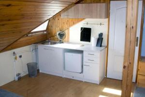 cocina con encimeras blancas y techo de madera en HomeHostel, en Varsovia