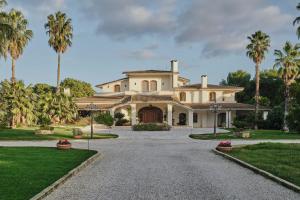 a house with palm trees in front of a driveway at Villa Lena Puglia in Oria