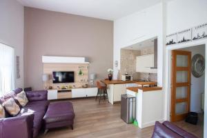 a living room with a purple couch and a kitchen at Mosspark Boulevard Exec Apartment ii - Free Parking in Glasgow