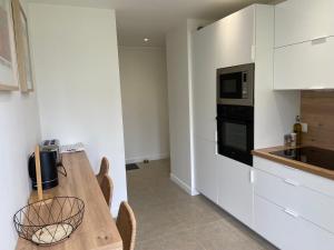 eine Küche mit Holztisch und Mikrowelle in der Unterkunft La Coloc' - Centre ville - Gare in Saint-Brieuc