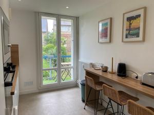 eine Küche mit einer Theke, Stühlen und einem Fenster in der Unterkunft La Coloc' - Centre ville - Gare in Saint-Brieuc