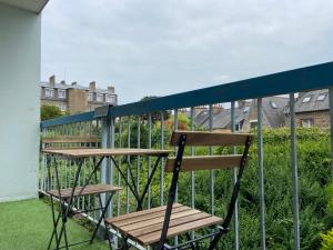 einen Holzstuhl und einen Tisch auf dem Balkon in der Unterkunft La Coloc' - Centre ville - Gare in Saint-Brieuc