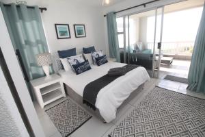 a bedroom with a large bed and a balcony at Laguna La Crete 12 in Uvongo Beach