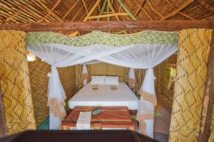 Postel nebo postele na pokoji v ubytování Kizingo Beach Eco Lodge