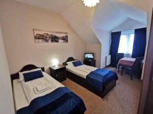 a hotel room with two beds and a television at SAS rooms & restaurant in Długie
