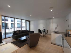 a living room with a couch and a table at Fully Serviced One Bed Apartment in Royal Wharf in London