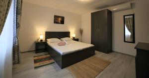 1 dormitorio con 1 cama, 2 mesas y 2 lámparas en Casa Ivana, en Murighiol