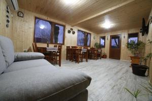 Una sala de estar con un sofá, una mesa y sillas. en Casa Ivana, en Murighiol