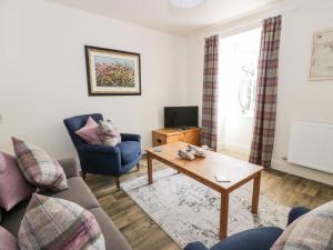 a living room with a couch and a coffee table at Saltflats Cottage - Rockcliffe in Dalbeattie