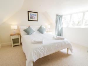 a white bed in a room with a window at Saltflats Cottage - Rockcliffe in Dalbeattie