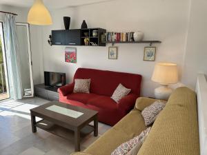 ネルハにあるSpacious family villa Aljamar 8aのリビングルーム(赤いソファ、テーブル付)