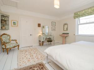 a bedroom with a bed and a chair and a desk at 29b Lower Street in Dartmouth