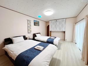 Kanazawa Seiren Le Lotus Bleu في كانازاوا: سريرين في غرفة الفندق عليها مناشف