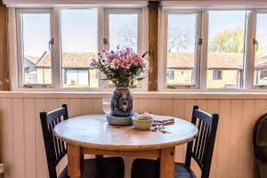 The Studio, Hoo في وودبريدج: طاولة غرفة الطعام مع إناء من الزهور عليها