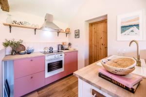 a kitchen with pink cabinets and a basket on a counter at The Studio, Hoo in Woodbridge