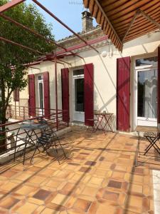a patio with chairs and tables on a building at LA MAISON D'ANTONIN 2 in Nîmes
