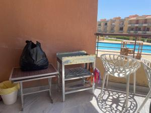 a balcony with two chairs and a table and a bag at Sun Mirror Chalet El Sokhna in Ain Sokhna