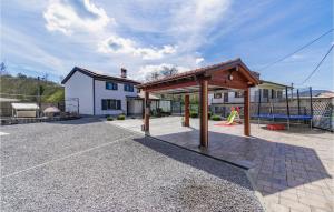 un pabellón con parque infantil frente a una casa en Beautiful Home In Divaca With Kitchen, en Divača