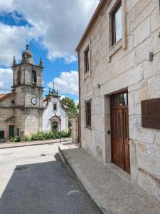 ein Gebäude mit einem Uhrturm und einer Kirche in der Unterkunft The Village House by CDV in Carrazeda de Ansiães