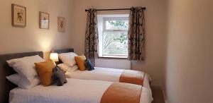 Giường trong phòng chung tại The Beautiful Bobbin - Premium Cottage with views, local walks, wood burner & pubs