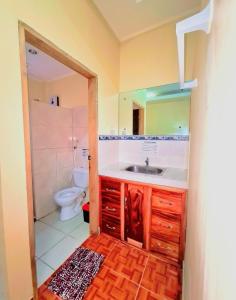 ein Badezimmer mit einem Waschbecken, einem WC und einem Spiegel in der Unterkunft La-Familia Guest House in Siquijor