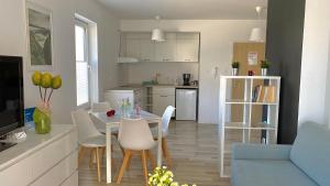 VELA MAR في كولوبرزيغ: مطبخ وغرفة معيشة مع طاولة وكراسي