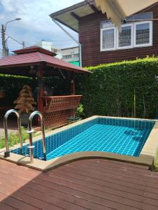 una piscina frente a una casa en Aran Cottage Ngamwongwan The Pool Villa in japanese Garden en Nonthaburi