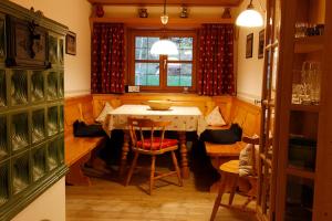 comedor con mesa, sillas y ventana en Ferienwohnungen am Ganglbach en Bayrischzell