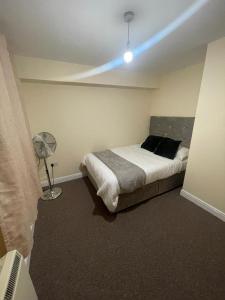 a bedroom with a bed with a blue light on it at TANGO APARTMENTs in London