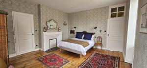 1 dormitorio con cama con almohadas azules y chimenea en Villa Mitsou, en Melle