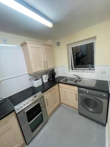 a kitchen with a sink and a stove at TANGO APARTMENTs in London