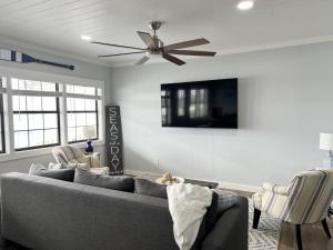 a living room with a couch and a ceiling fan at Reel House in Gulf Shores