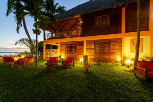 una casa con sillas y una mesa frente a ella en La Plage de Le Zahir, en Nosy Be