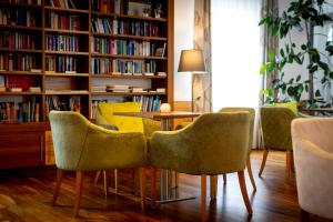 ein Esszimmer mit einem Tisch und Stühlen in einer Bibliothek in der Unterkunft Hotel Auszeit St Lambrecht in Sankt Lambrecht