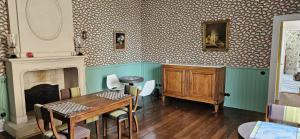 a dining room with a table and a fireplace at Villa Mitsou in Melle
